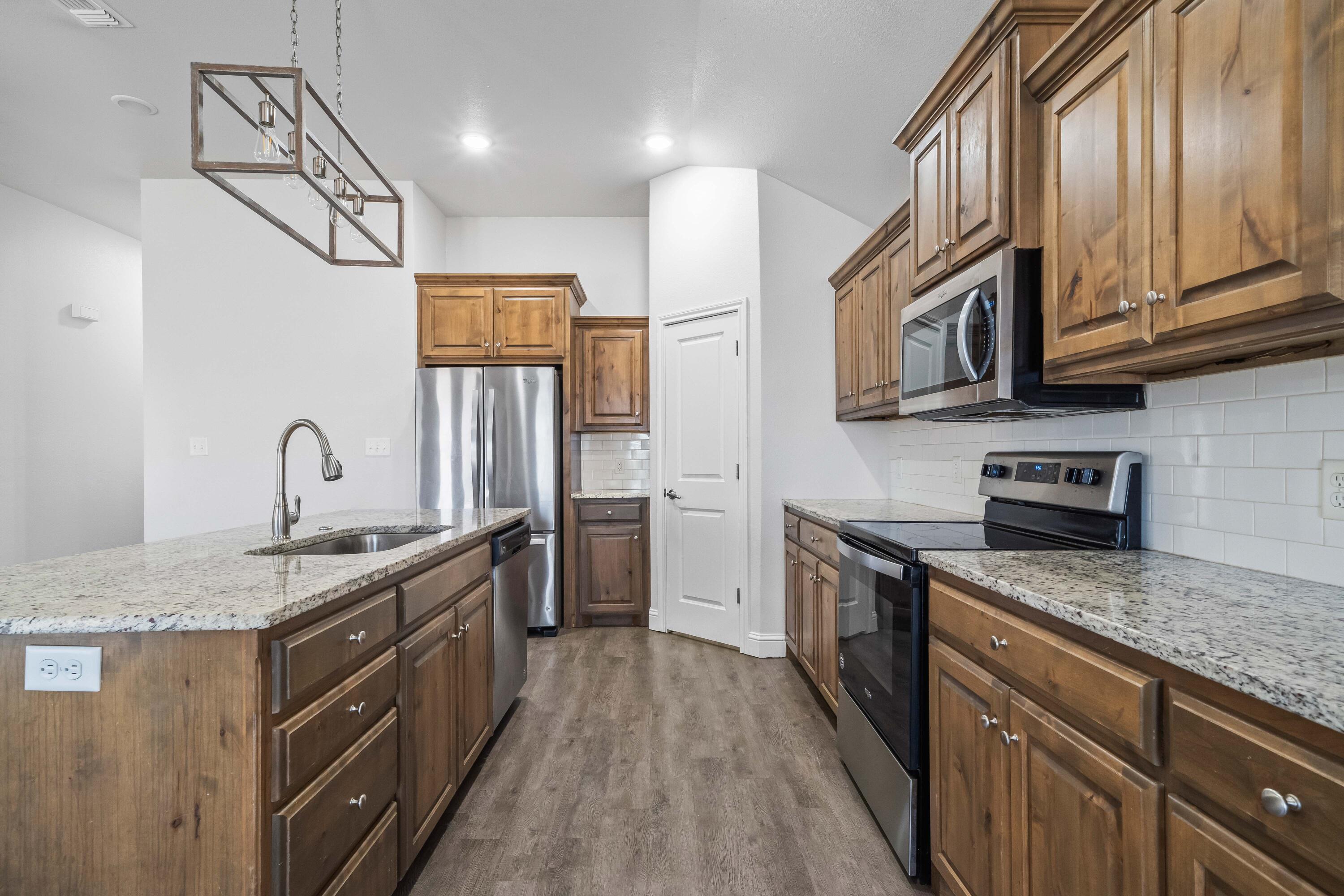 7523 87th Street Lubbock, TX 79424 - Photo 6 of 23 a kitchen with stainless steel appliances granite countertop a sink stove and cabinets