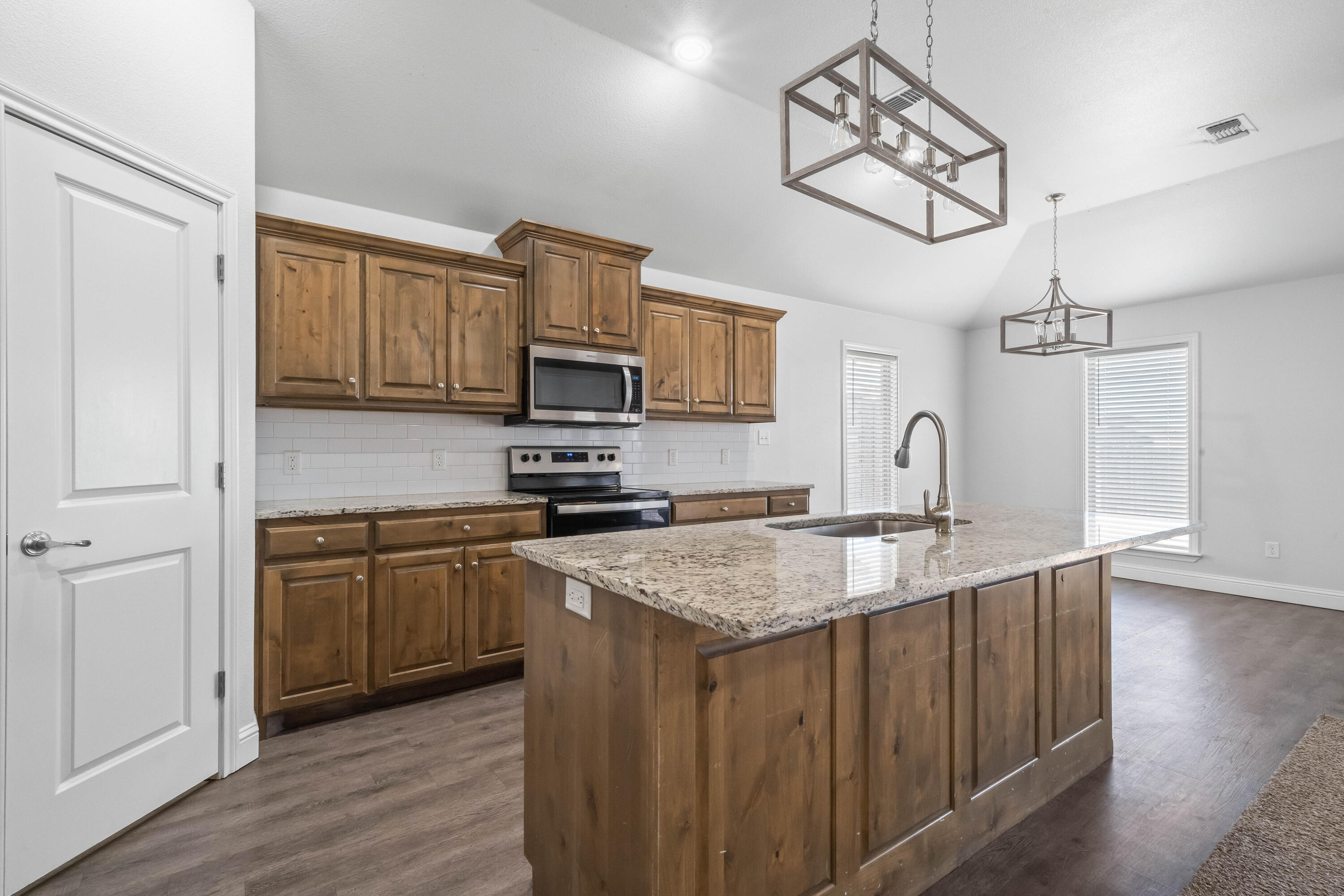 7523 87th Street Lubbock, TX 79424 - Photo 7 of 23 a kitchen with stainless steel appliances granite countertop a sink refrigerator and microwave