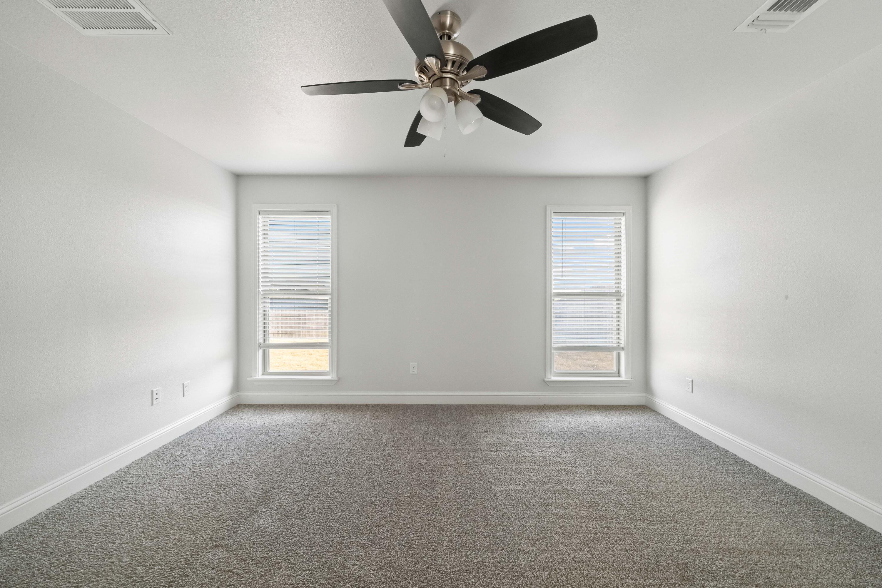 7523 87th Street Lubbock, TX 79424 - Photo 10 of 23 an empty room with windows and fan