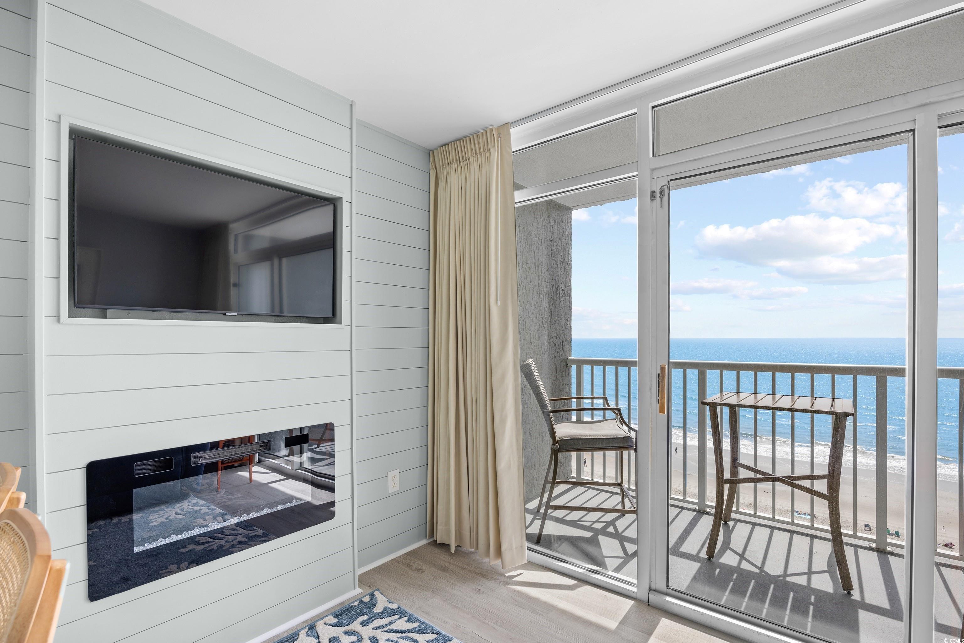 161 Seawatch Drive, Unit 1012 Myrtle Beach, SC 29572 - Photo 13 of 34 Doorway with wood finished floors, wooden walls, and a glass covered fireplace