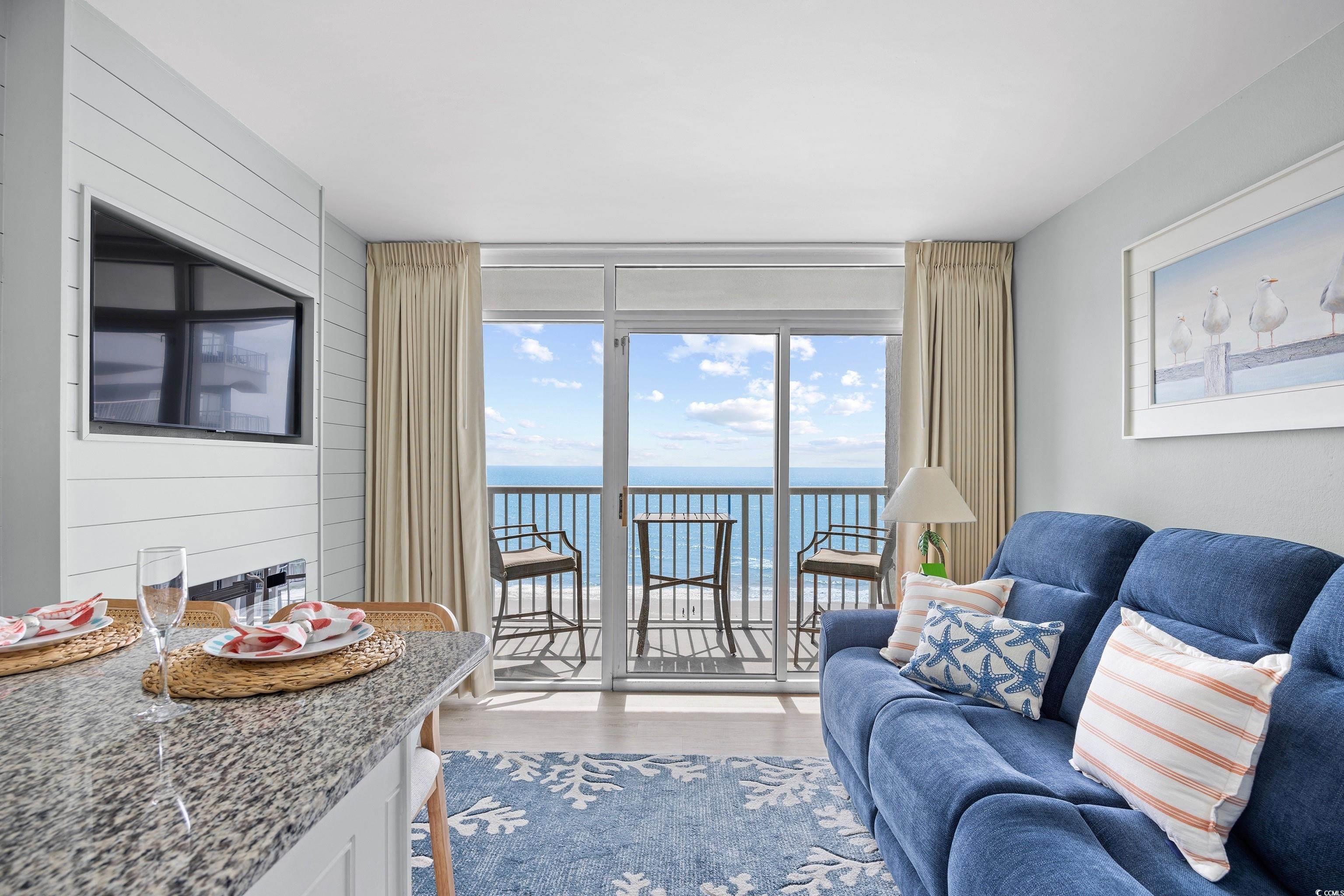 161 Seawatch Drive, Unit 1012 Myrtle Beach, SC 29572 - Photo 14 of 34 Living area featuring wooden walls, light wood-style flooring, and floor to ceiling windows