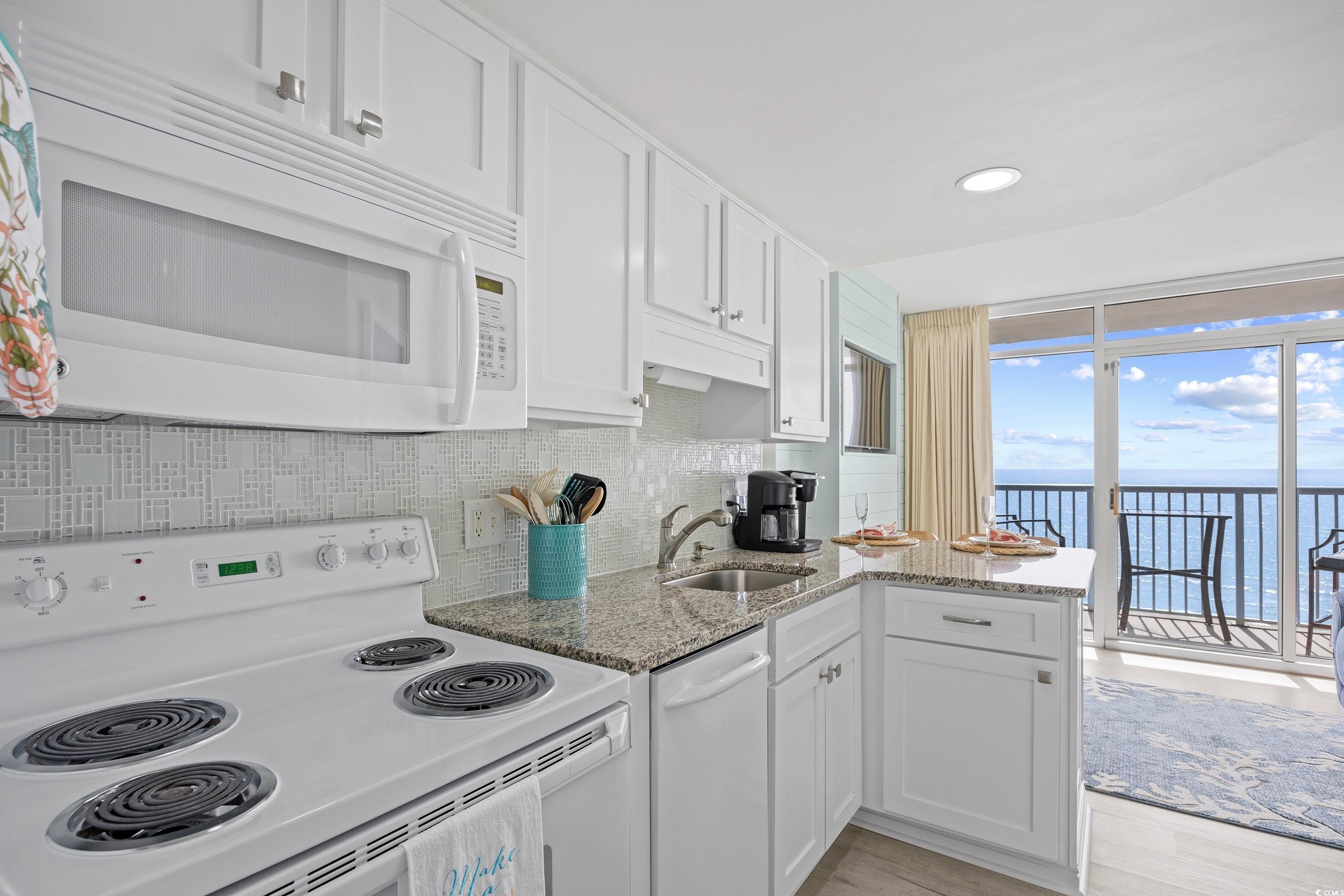 161 Seawatch Drive, Unit 1012 Myrtle Beach, SC 29572 - Photo 22 of 34 Kitchen with white appliances, light stone counters, white cabinets, backsplash, and recessed lighting