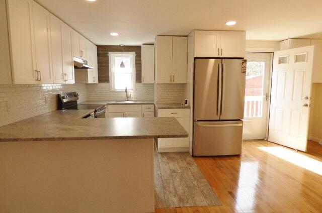 3 Circuit Road North West Yarmouth, MA 02673 - Photo 5 of 28 a kitchen with stainless steel appliances granite countertop a refrigerator a sink a stove a microwave and white cabinets with wooden floor