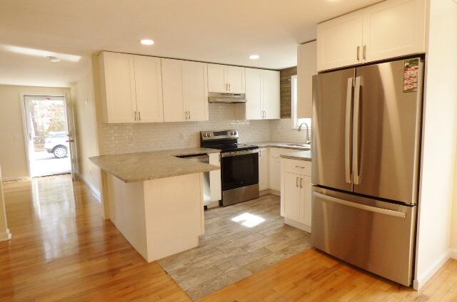 3 Circuit Road North West Yarmouth, MA 02673 - Photo 7 of 28 a kitchen with a refrigerator a stove top oven and wooden floor