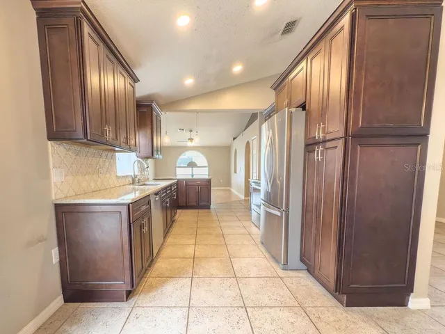 a large kitchen with a large window and stainless steel appliances