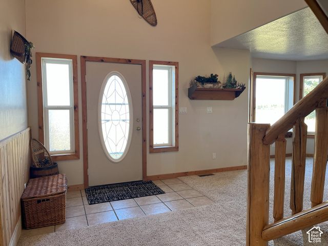 750 South Big Road Soda Springs, ID 83276 - Photo 12 of 40 Entryway featuring a decorative oval-lite door, two sidelight windows, tile flooring, and wood-paneled walls