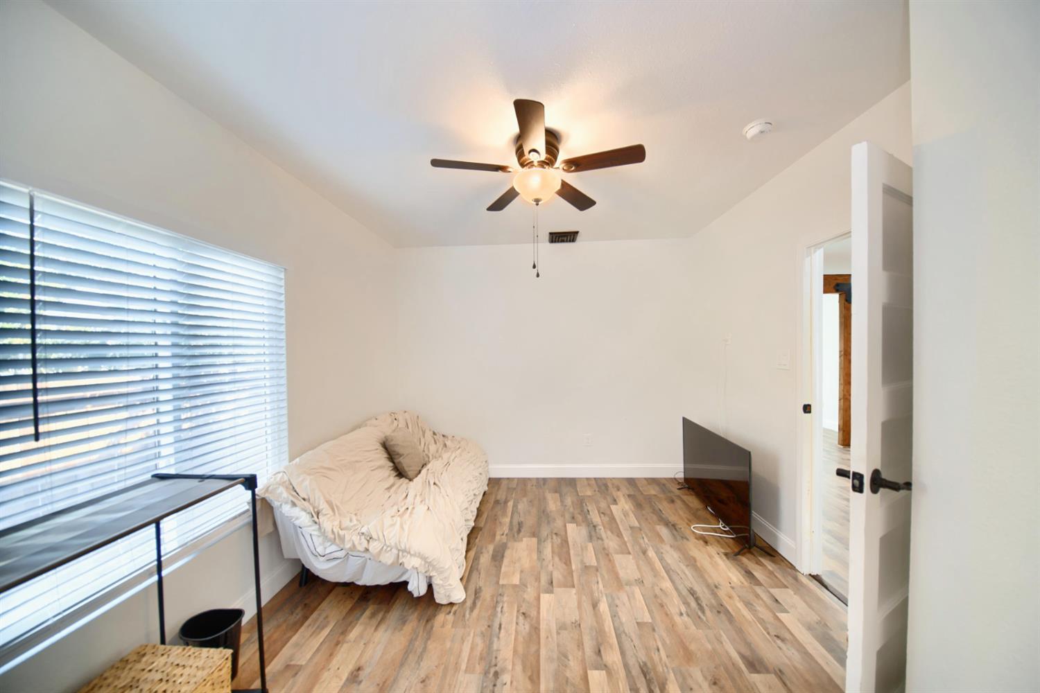 131 5th Street Gustine, CA 95322 - Photo 50 of 92 a view of a bedroom with wooden floor and a ceiling fan