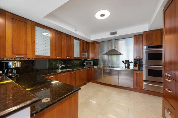 a kitchen with stainless steel appliances granite countertop a stove a sink and a microwave