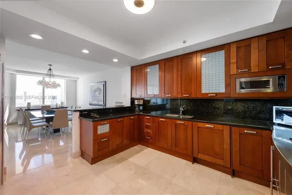 a large kitchen with stainless steel appliances granite countertop a lot of cabinets a sink and a counter top space