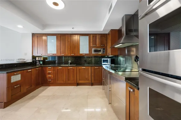 a large kitchen with stainless steel appliances granite countertop a stove a sink and a microwave