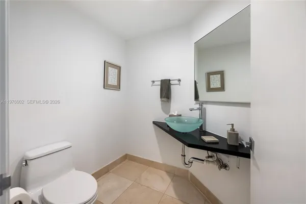 a bathroom with a toilet a sink and mirror