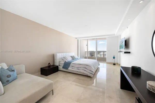 a bedroom with a bed and large windows