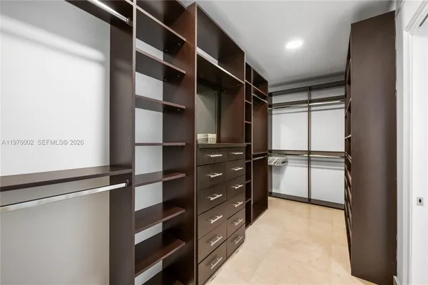 a view of walk in closet with empty racks