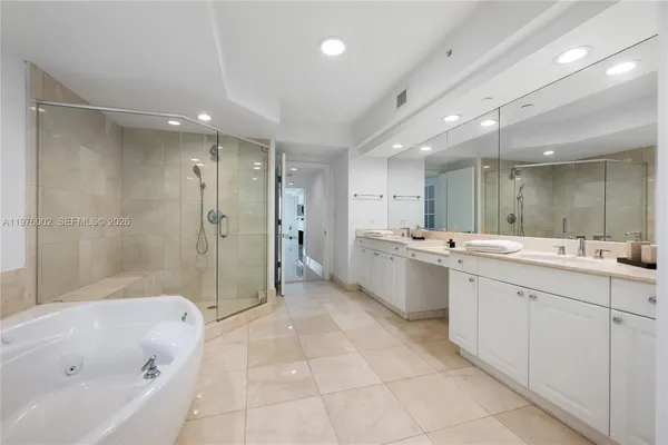 a large bathroom with a large mirror vanity shower and a sink