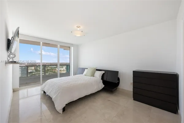 a bedroom with a bed and large window