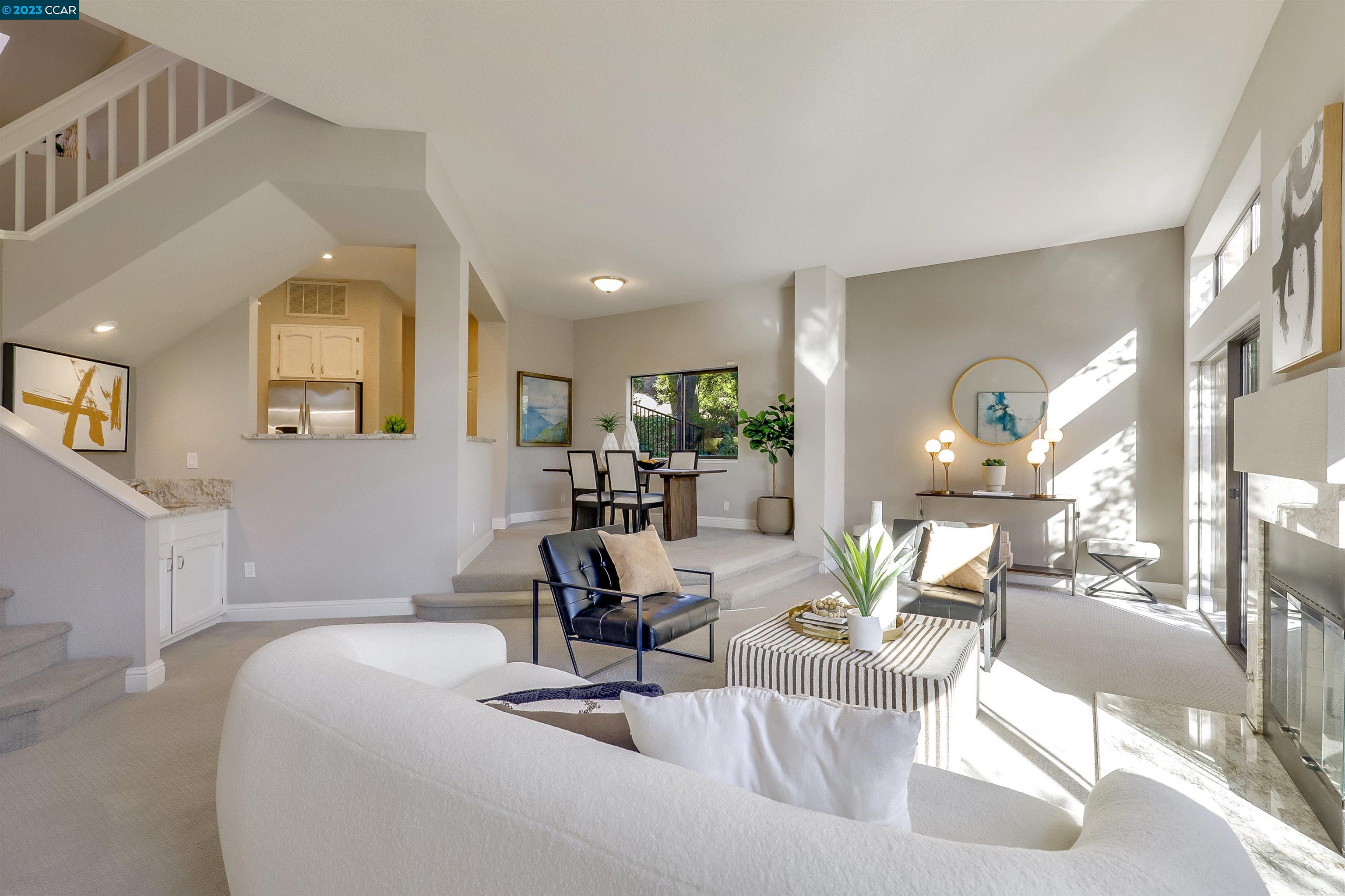 a living room with couches a dining table and couches with wooden floor