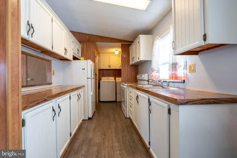 a kitchen with granite countertop a sink a counter space stainless steel appliances and cabinets