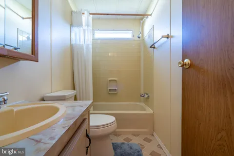 a bathroom with a granite countertop toilet a sink and bathtub