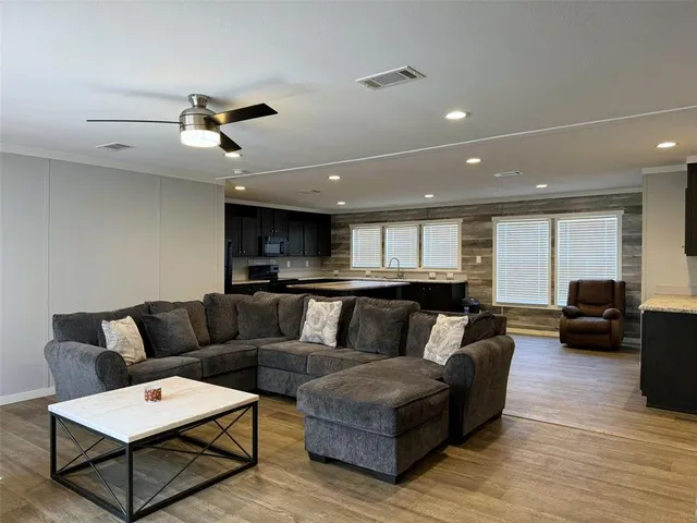a living room with furniture and a wooden floor