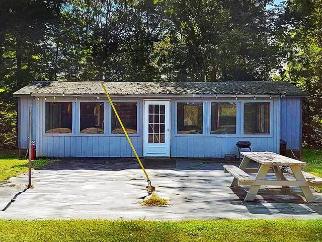 a kitchen with stainless steel appliances granite countertop a stove top oven a sink dishwasher a dining table and chairs with wooden floor