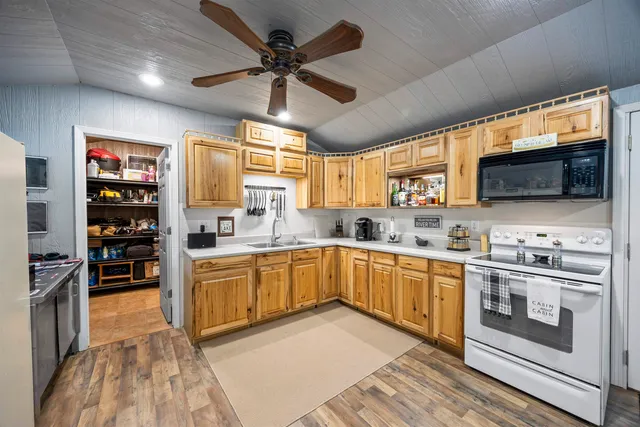 a kitchen with stainless steel appliances granite countertop a sink dishwasher a stove and a microwave oven with cabinets