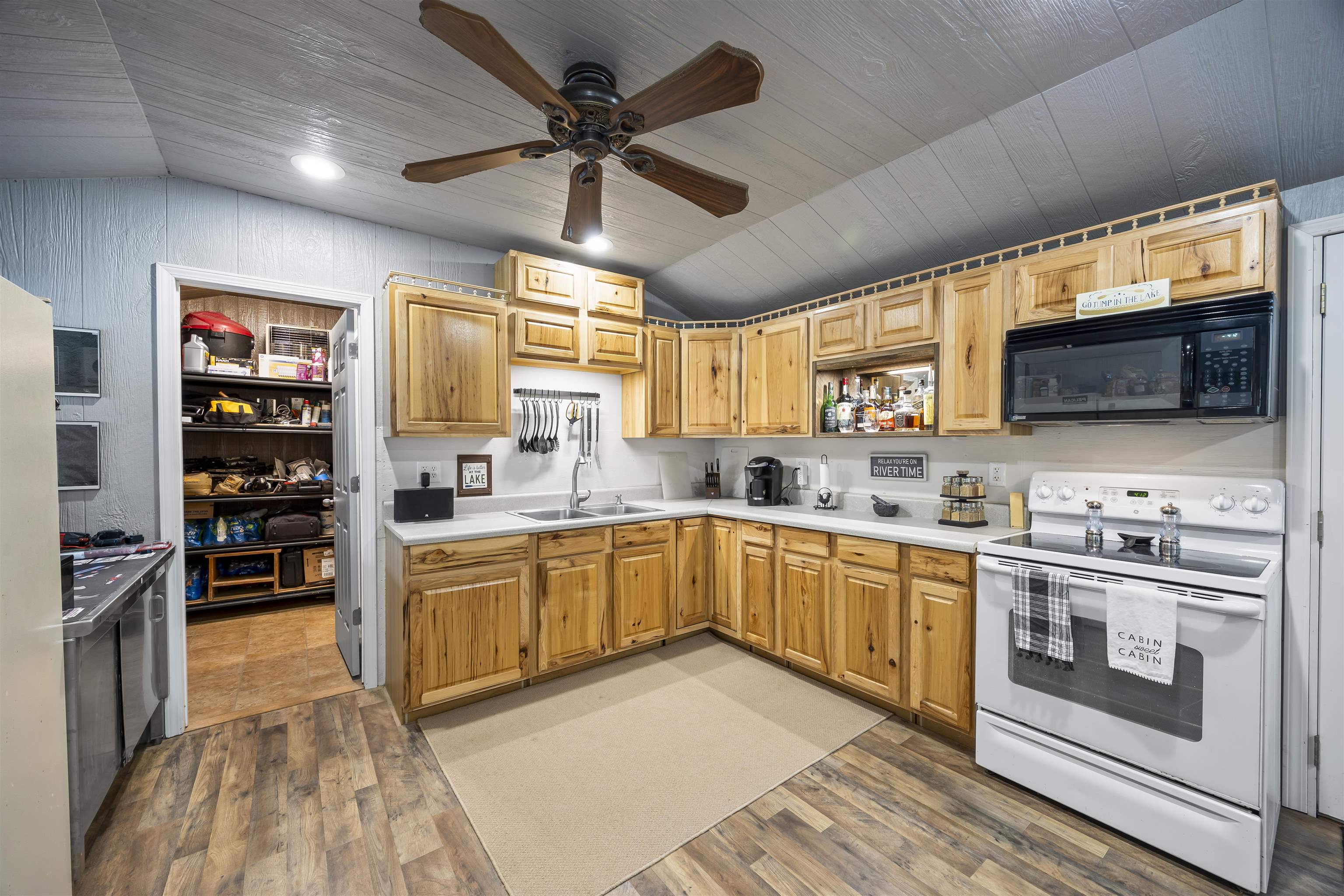 4830 Kendall Road Hornbeak, TN 38232 - Photo 4 of 37 a kitchen with stainless steel appliances granite countertop a stove top oven a sink dishwasher a dining table and chairs with wooden floor