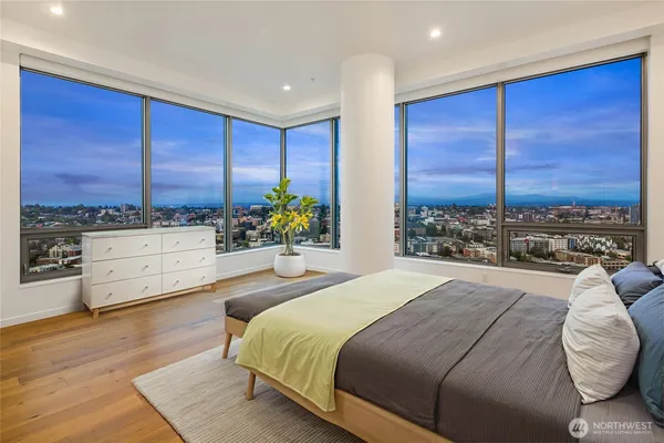 a bedroom with a bed and large windows