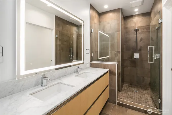a bathroom with a granite countertop sink mirror and shower