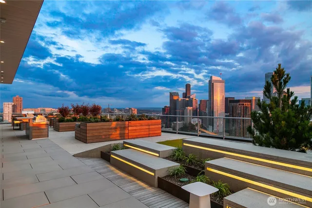 a roof deck with couches and city view