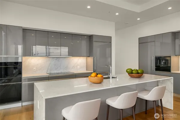 a kitchen with stainless steel appliances a table and chairs in it