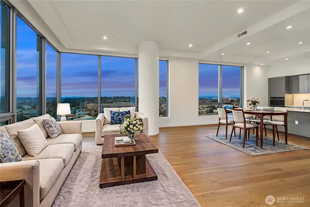 a living room with furniture wooden floor and a large window