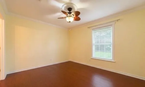 an empty room with a window and a fan