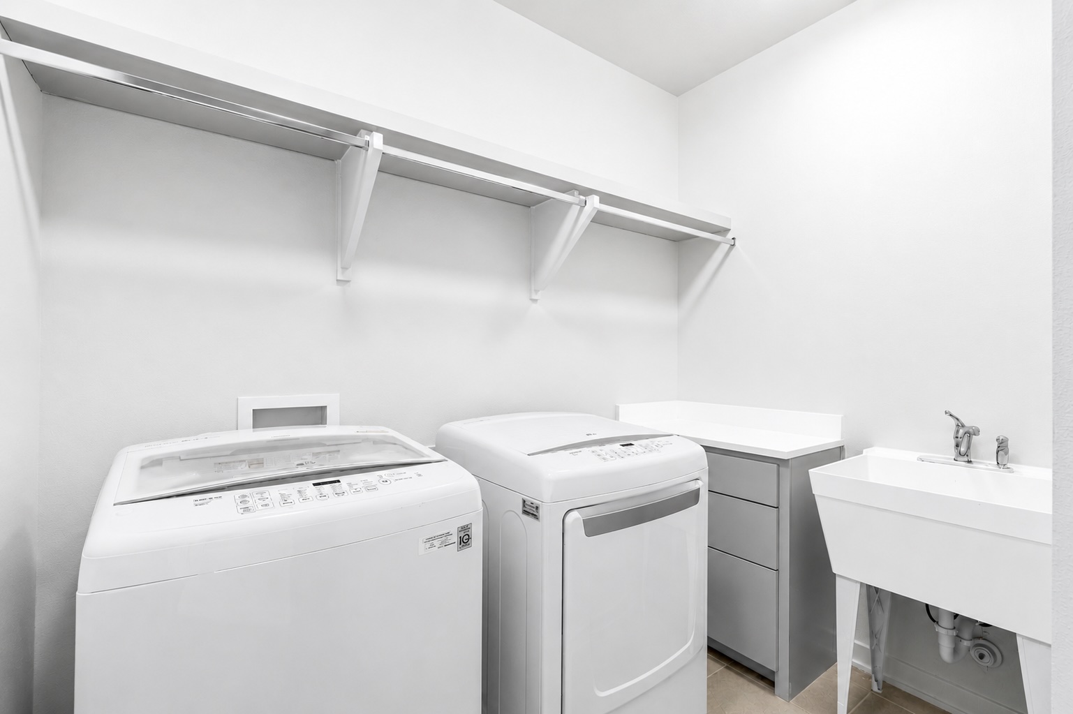 2520 Sutherland Street Austin, TX 78746 - Photo 23 of 26 Functional laundry room equipped with upper shelving and a utility sink for convenience.