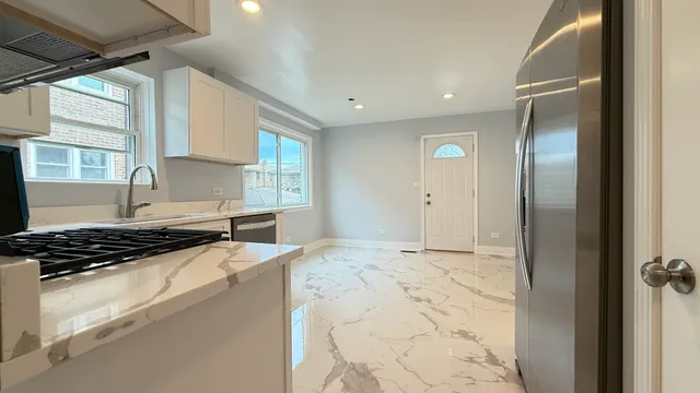 a kitchen with stainless steel appliances granite countertop a stove a sink and a refrigerator