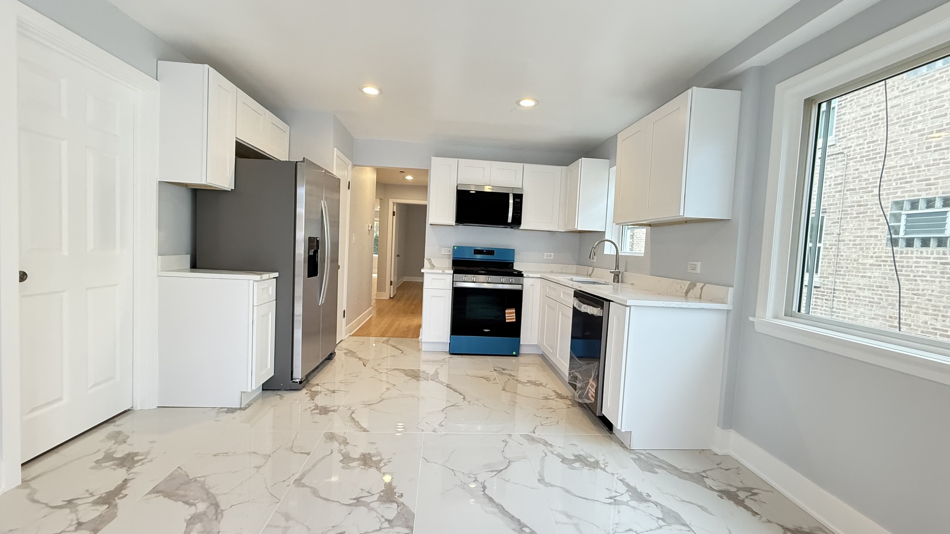 1345 North Latrobe Avenue Chicago, IL 60651 - Photo 21 of 50 a kitchen with stainless steel appliances kitchen island granite countertop a refrigerator and a stove top oven