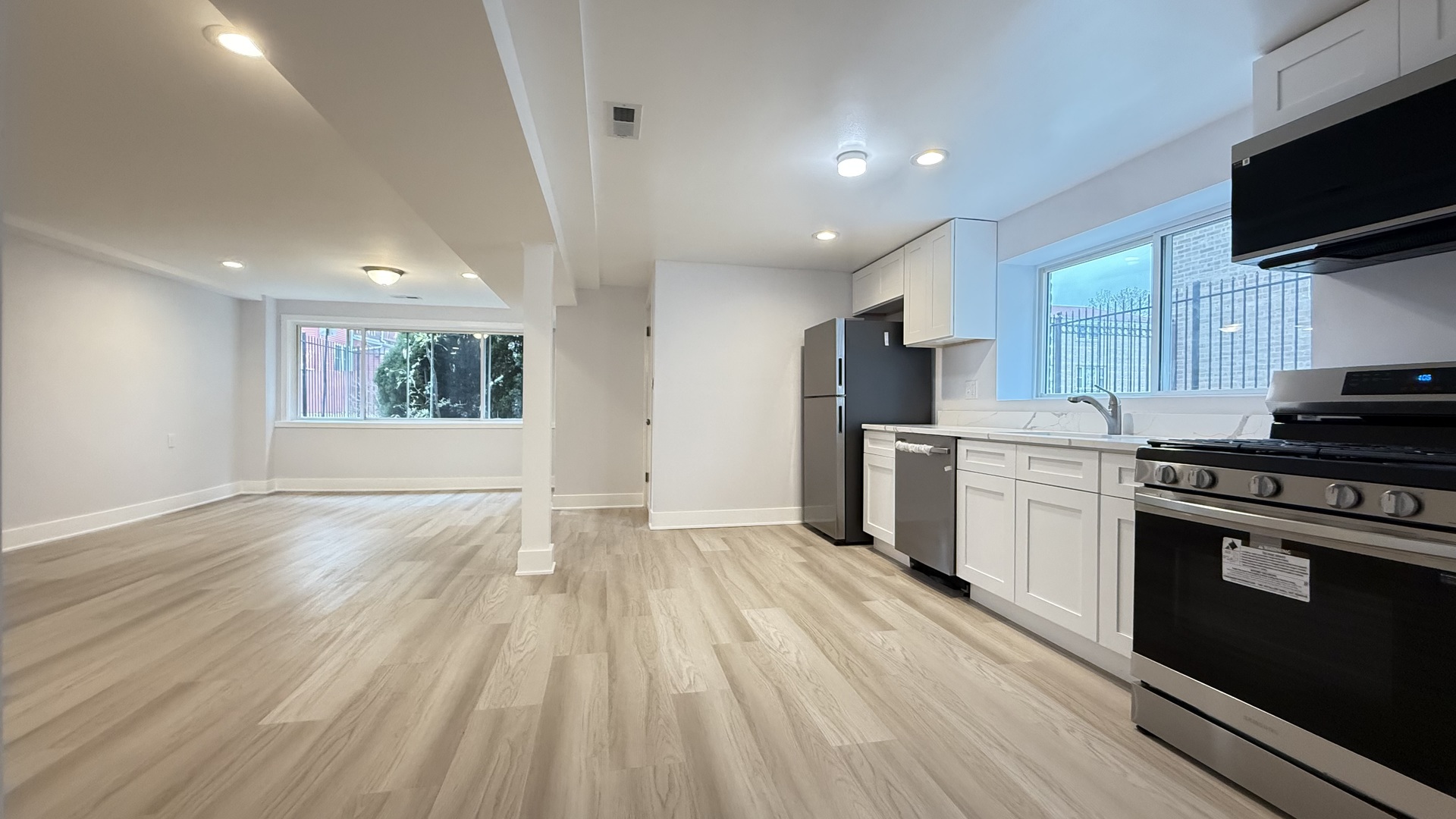 1345 North Latrobe Avenue Chicago, IL 60651 - Photo 43 of 50 a kitchen with granite countertop a stove top oven a sink dishwasher a refrigerator and white cabinets with wooden floor