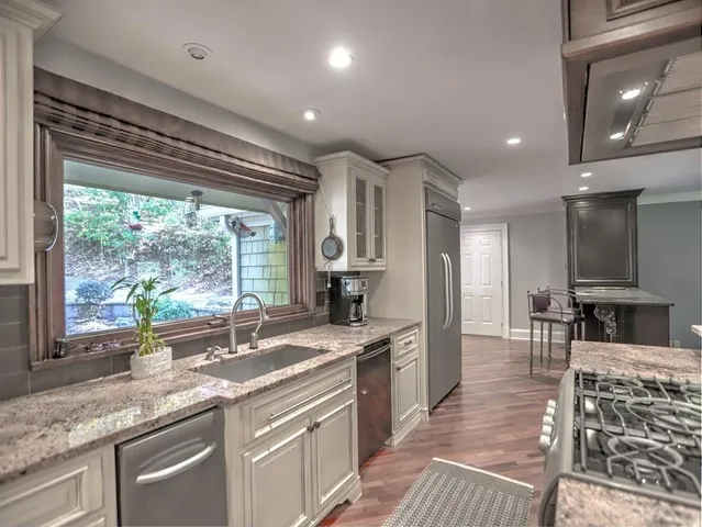 a kitchen with stainless steel appliances granite countertop a sink stove and cabinets