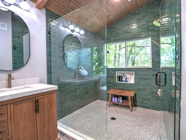 a bathroom with a granite countertop double vanity sink toilet and a mirror