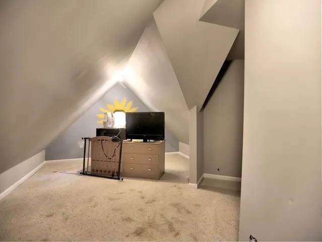 a spacious bedroom with a bed and a chandelier