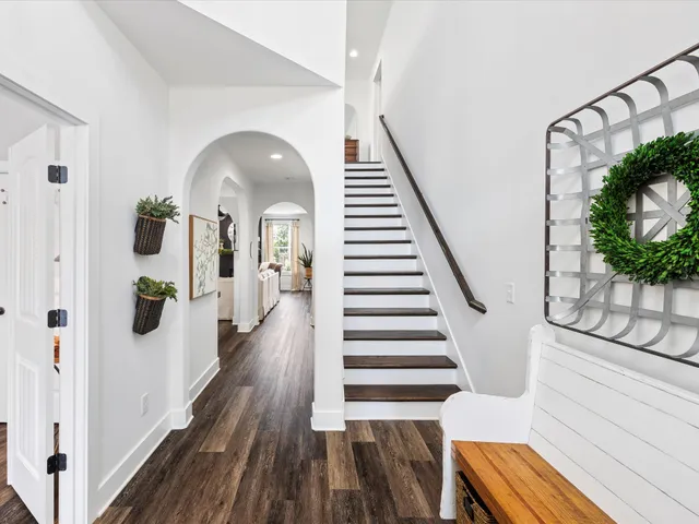 a kitchen with stainless steel appliances granite countertop a stove top oven a refrigerator a sink and a fireplace with wooden floor