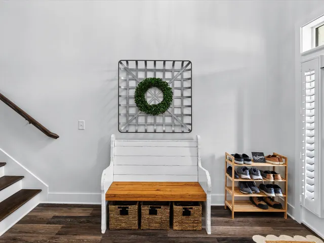 a living room with furniture a chandelier and wooden floor