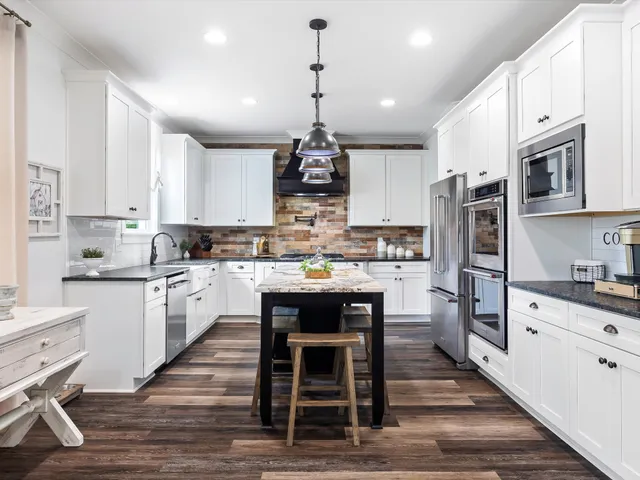 a living room with furniture kitchen view and a chandelier
