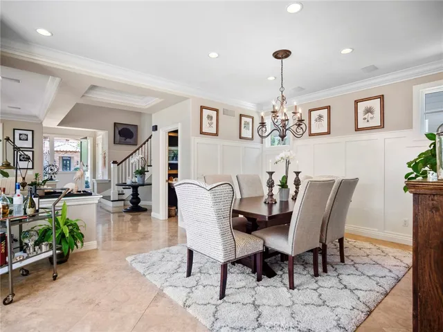 a dining room with furniture a chandelier and wooden floor