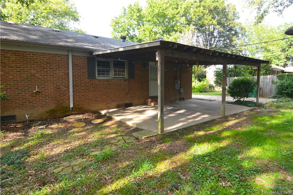 1224 Stallings Road Matthews, NC 28104 - Photo 3 of 6 a backyard of a house with table and chairs under an umbrella