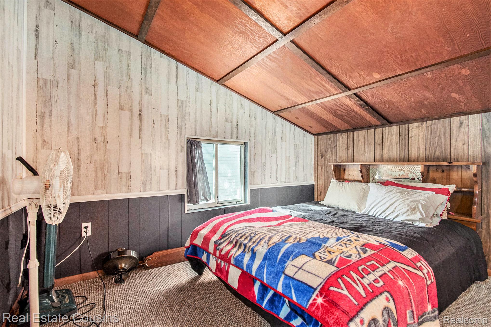 1734 Forest Road Harrison, MI 48625 - Photo 17 of 31 Carpeted bedroom with wood walls and vaulted ceiling