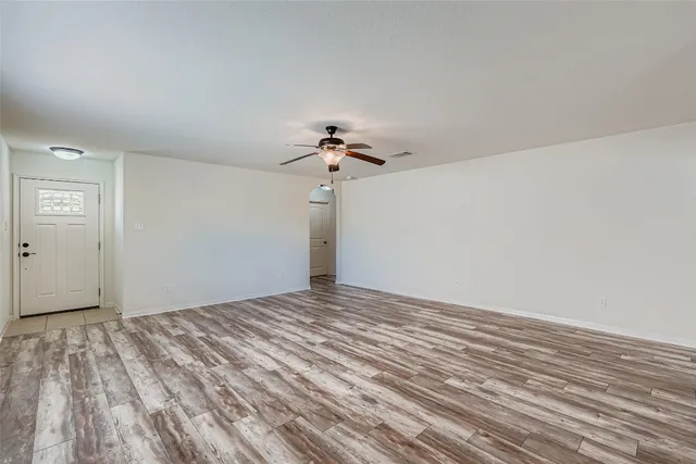 a view of a big room with wooden floor closet and chandelier fan