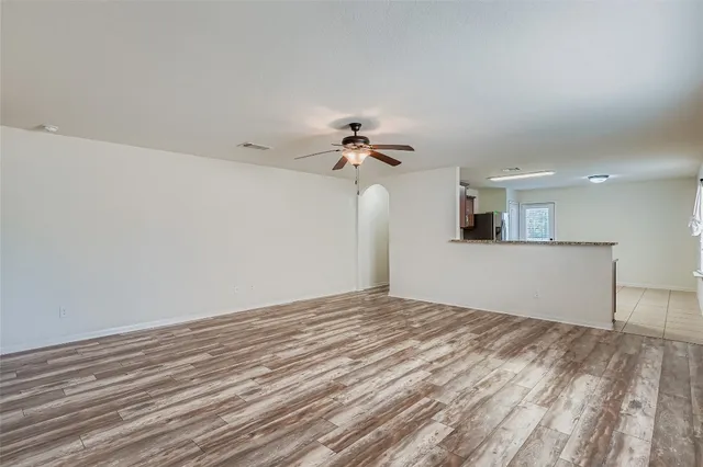 a view of a big room with wooden floor and a ceiling fan