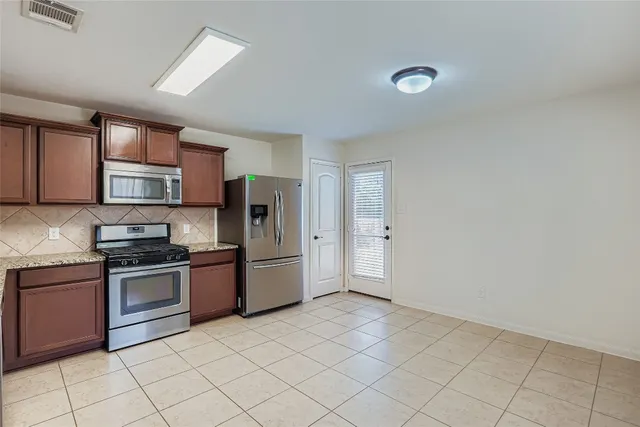 a kitchen with stainless steel appliances granite countertop a stove top oven a sink and dishwasher