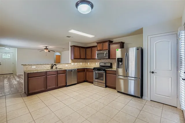 a large kitchen with cabinets and stainless steel appliances