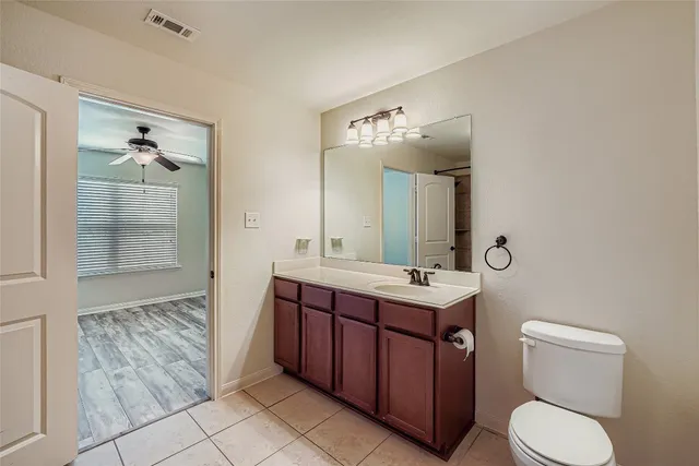 a bathroom with a toilet sink vanity and mirror